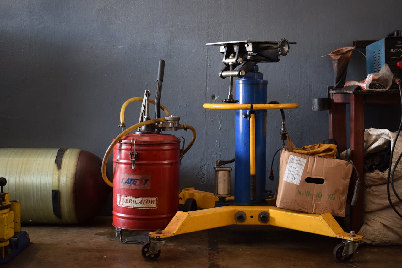A well-equipped workshop features various machinery and an industrial lubricator.