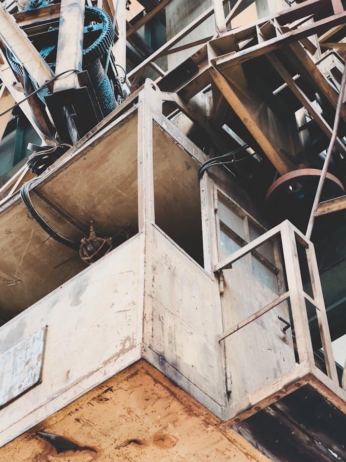 Close-up of an aged industrial crane with visible rust and worn metal parts.